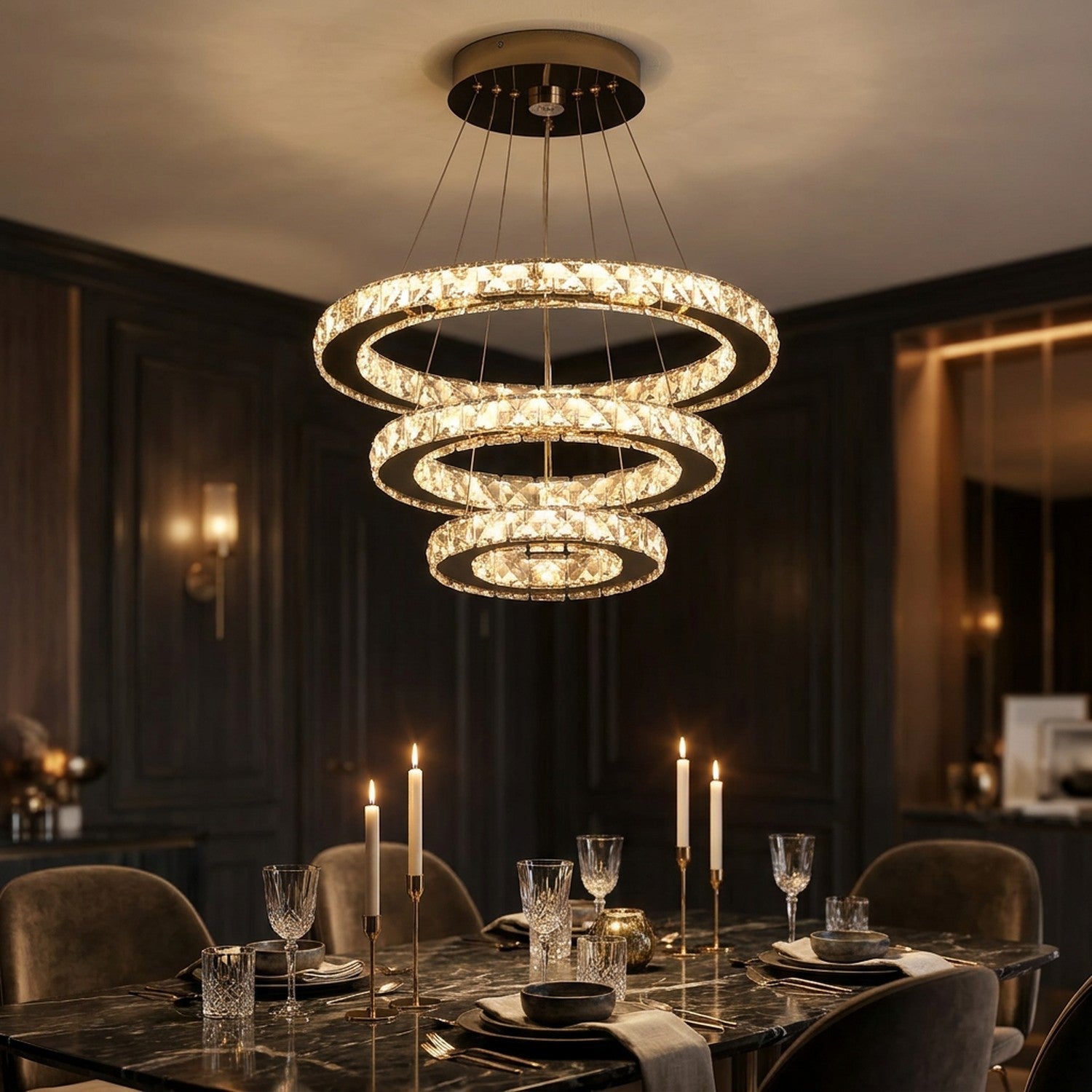 Lustre en cristal doré éclairant une table dressée aux chandelles dans une salle à manger