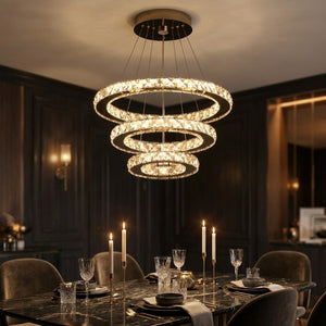 Lustre en cristal doré éclairant une table dressée aux chandelles dans une salle à manger