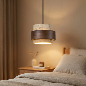 Suspension beige en pierre et bois allumée près d'un lit dans une chambre chaleureuse