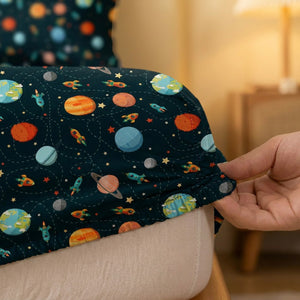 Gros plan de l'élastique du drap housse cosmos tenu à la main sur le matelas