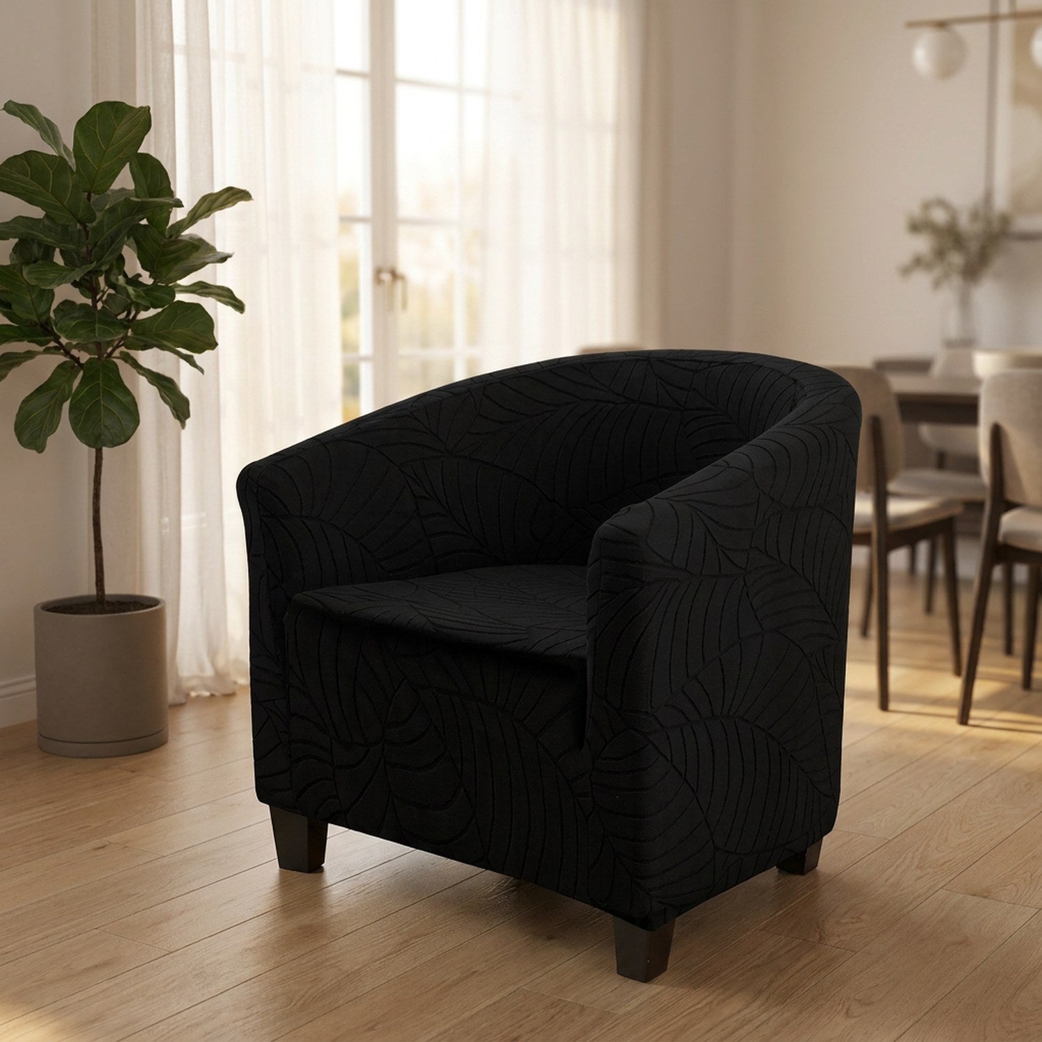 Fauteuil club noir à motif jacquard dans un salon lumineux près d'une plante