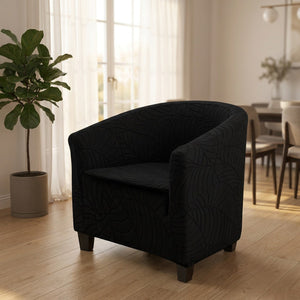 Fauteuil club noir à motif jacquard dans un salon lumineux près d'une plante