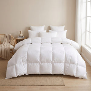 Couette blanche sur un lit dans une chambre épurée avec fauteuil en rotin