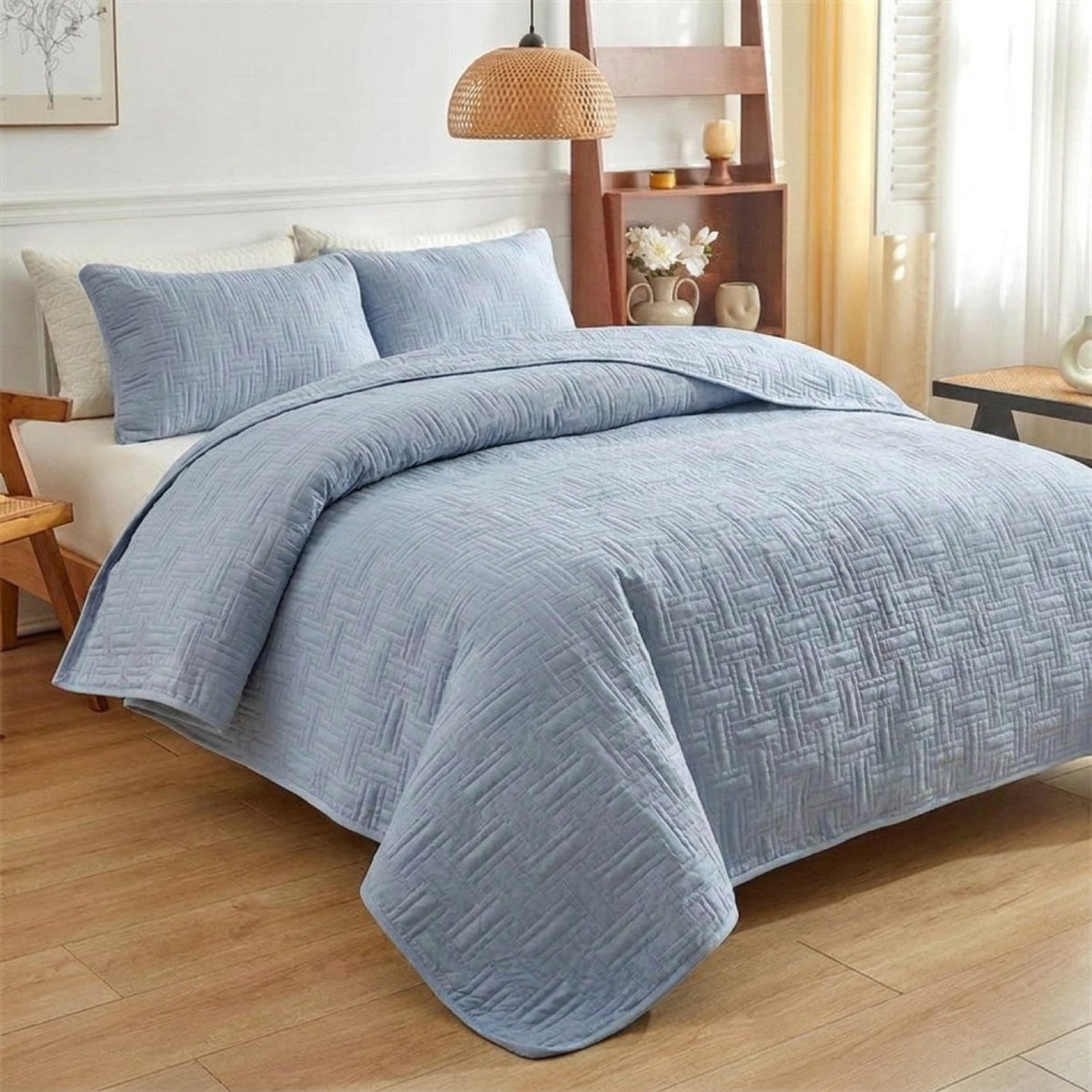 Couvre-lit matelassé bleu dans une chambre scandinave au sol en bois clair