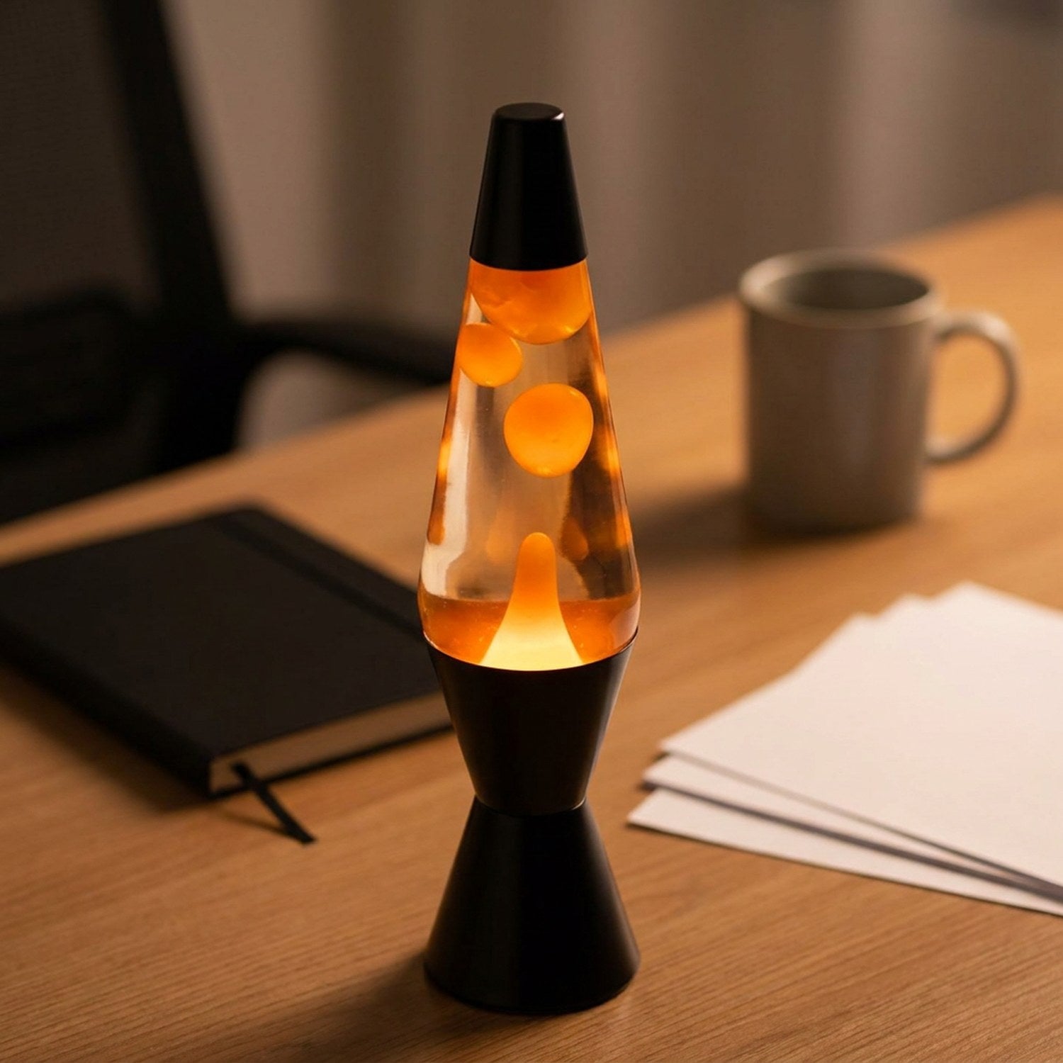 Lampe à lave allumée sur un bureau près d un ordinateur portable
