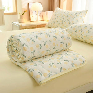 Couette à imprimé fleuri roulée sur un lit avec taies d'oreiller assorties