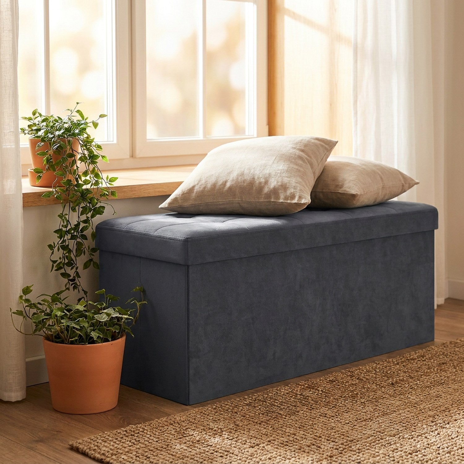 Banc de rangement en velours gris sous une fenêtre avec deux coussins