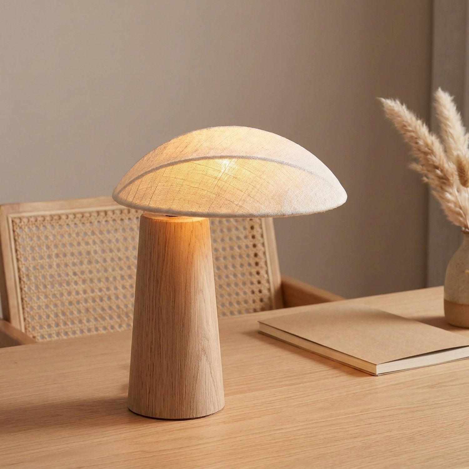Lampe champignon en bois allumée sur un bureau à côté d'une chaise en rotin