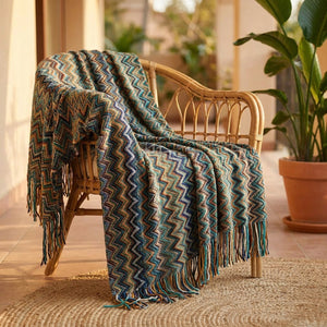 Plaid tricoté drapé sur un fauteuil en rotin sur une terrasse ensoleillée