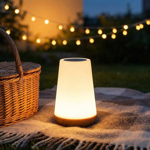 Lampe tactile posée sur un plaid de pique nique en extérieur au crépuscule