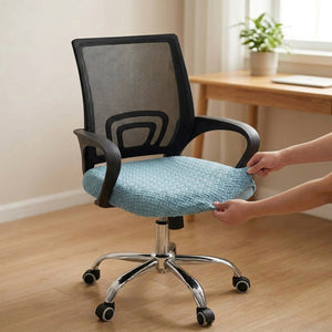 Mains enfilant la housse d'assise extensible bleue sur le coussin d'une chaise de bureau