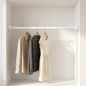 Tringle télescopique blanche installée dans un dressing avec vêtements suspendus sur cintres