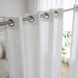 Détail des œillets métalliques et du tissage rayé du voilage blanc