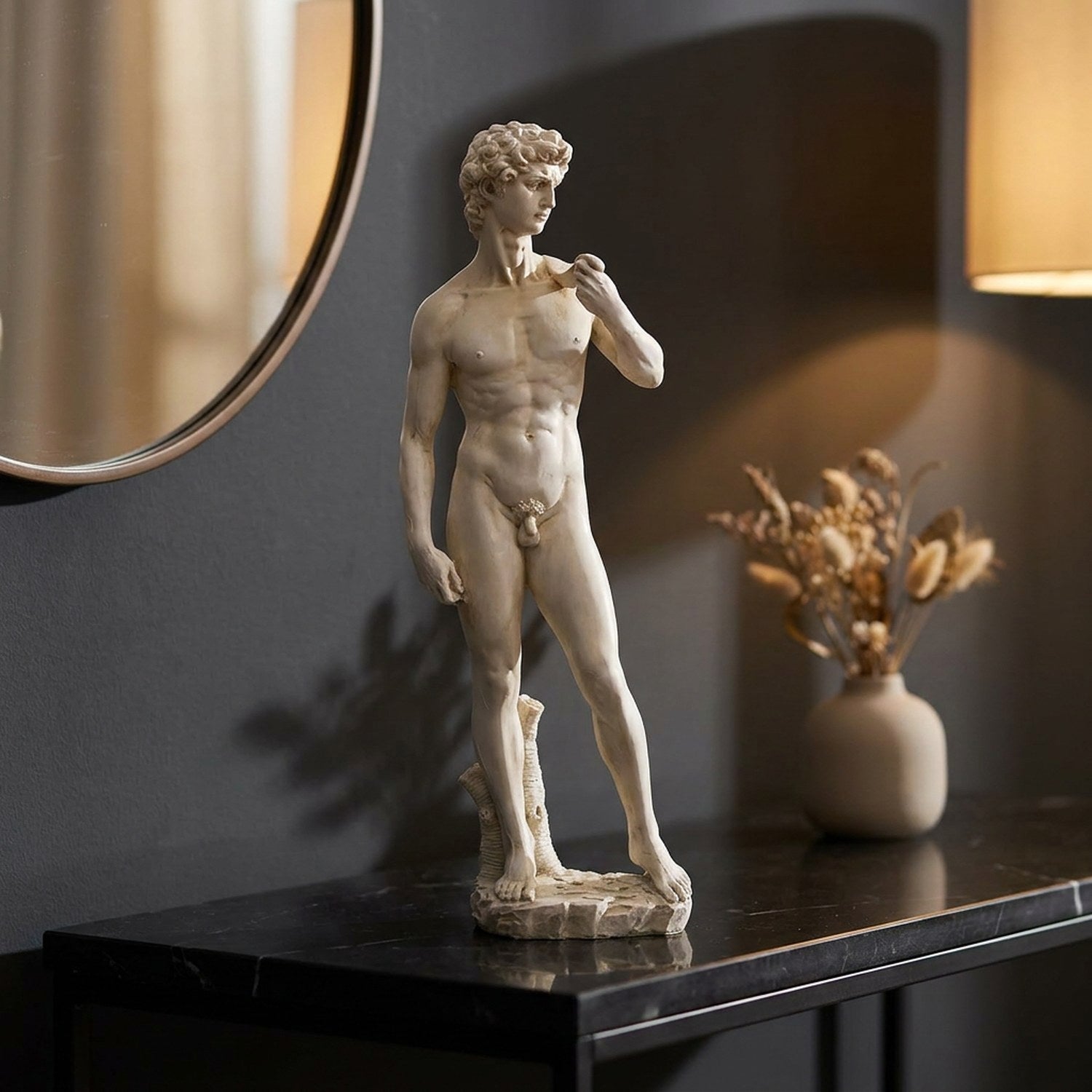 Statue du David en résine ivoire sur une console noire dans une entrée élégante