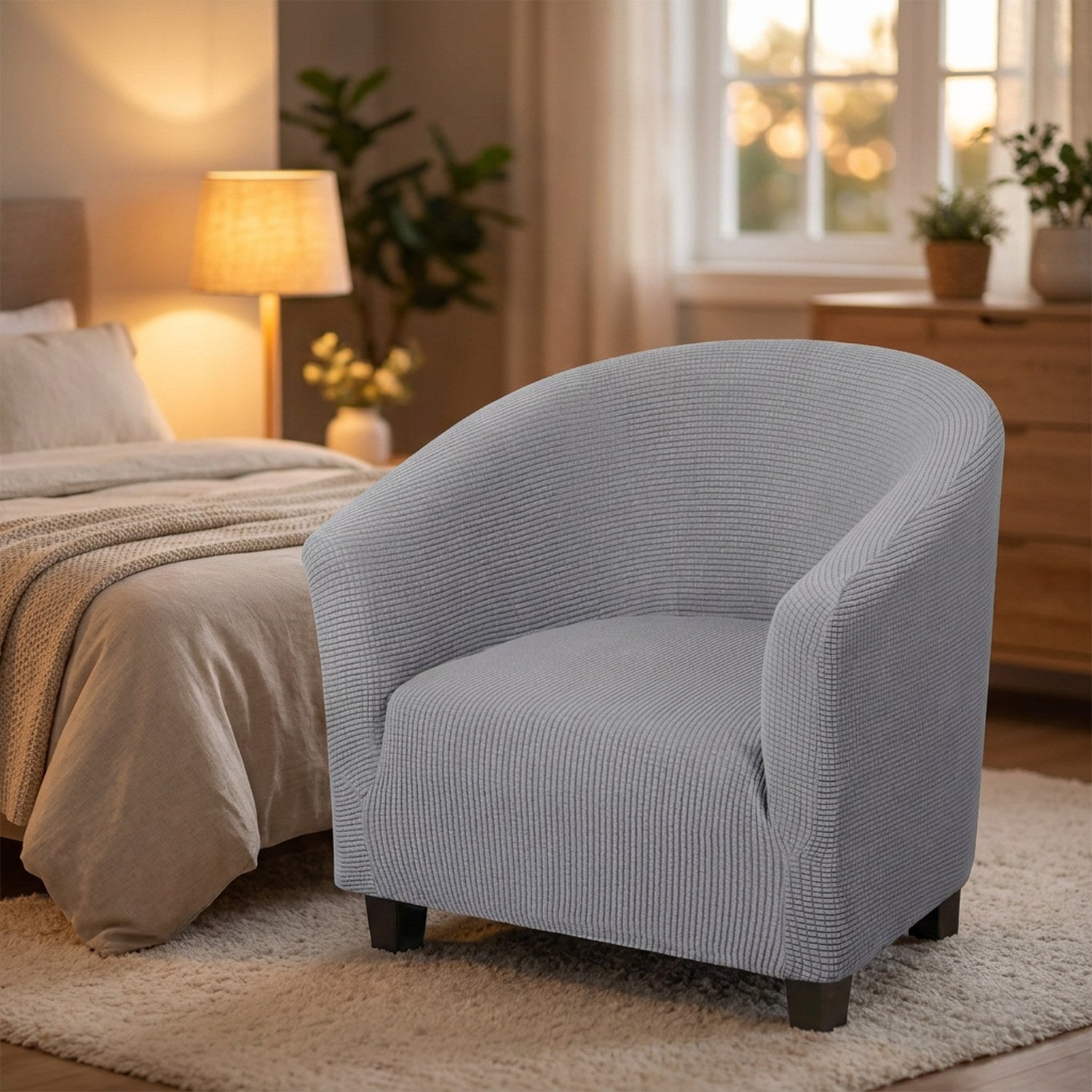 Housse de fauteuil cabriolet grise dans une chambre chaleureuse au pied du lit