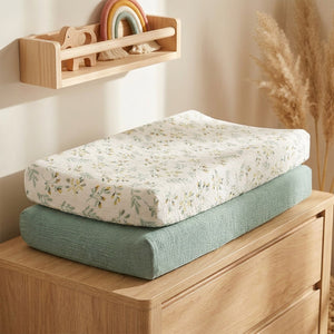 Housse de matelas à langer sur une commode bois dans une chambre bébé bohème