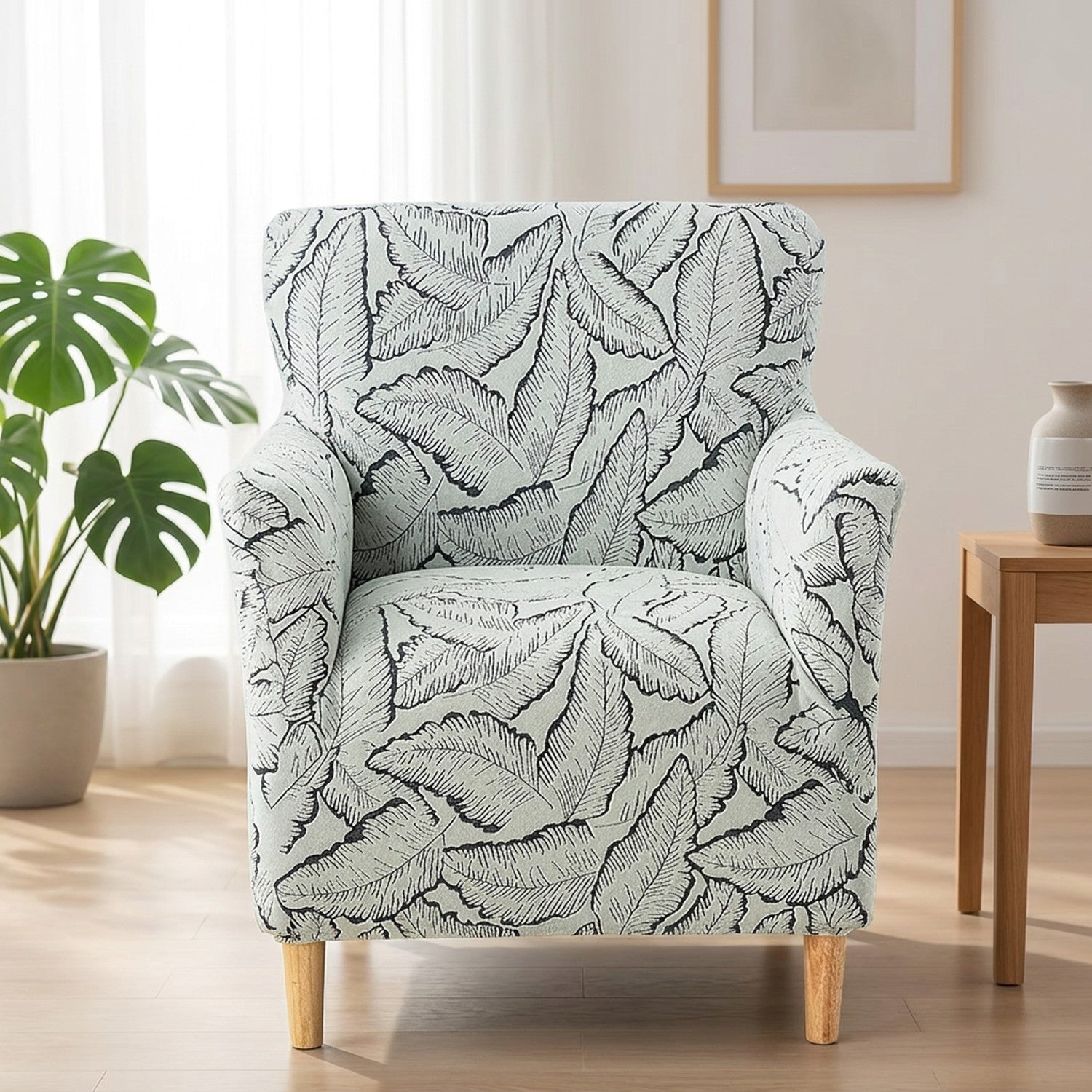 Housse de fauteuil grise à motif de feuilles installée sur un fauteuil dans un salon moderne