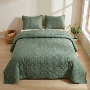 Couvre-lit matelassé vert posé à plat sur un lit dans une chambre scandinave épurée