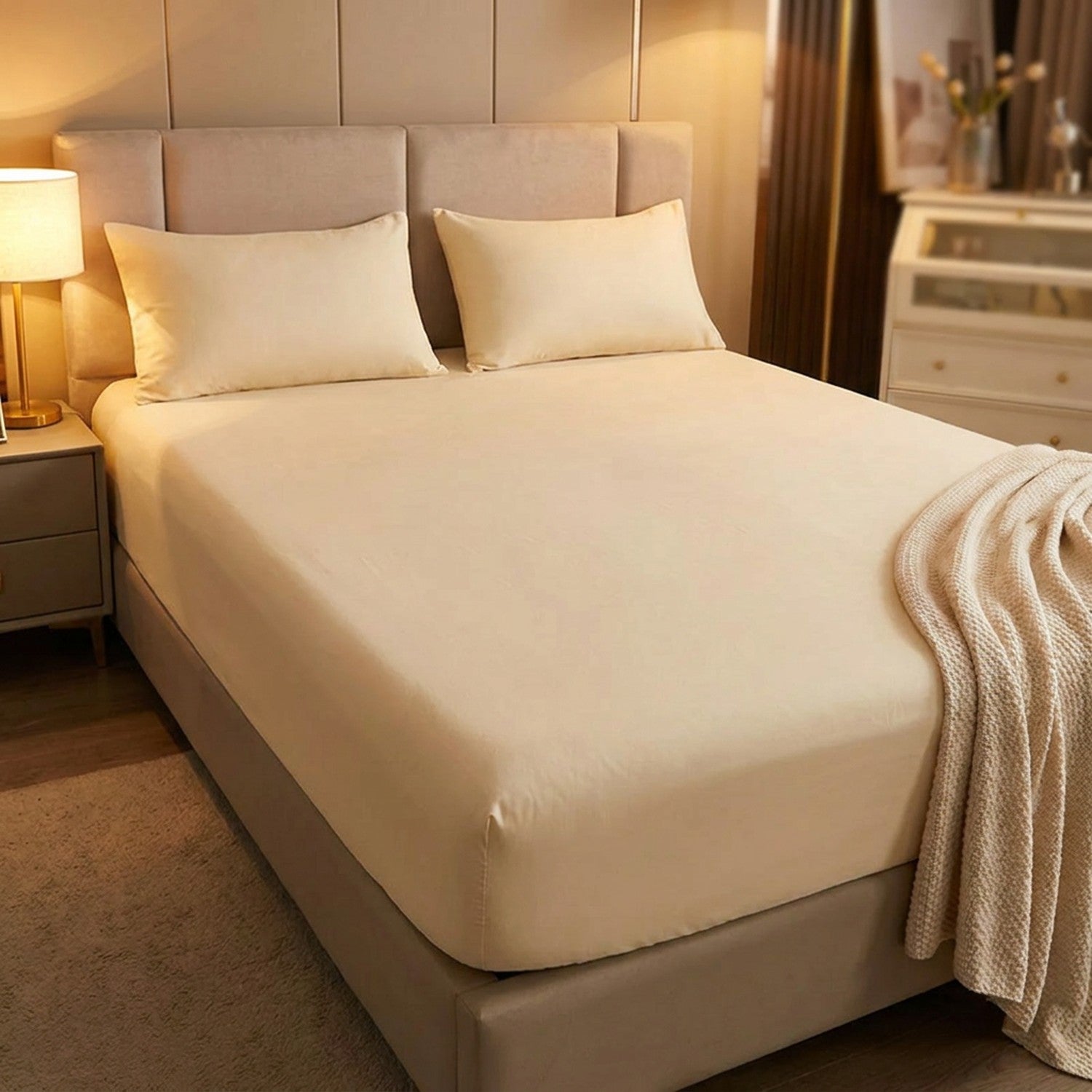 chambre chaleureuse avec un drap-housse crème et une tête de lit capitonnée