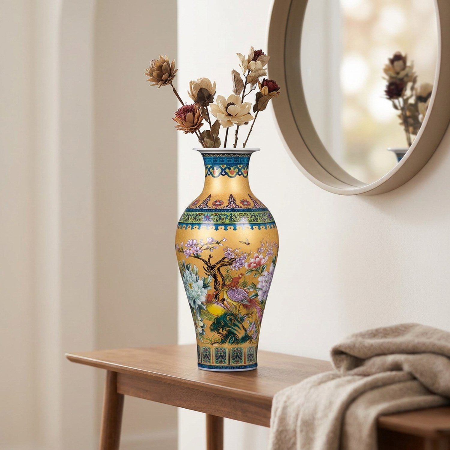 Vase chinois doré garni de fleurs séchées sur une console d'entrée près d'un miroir
