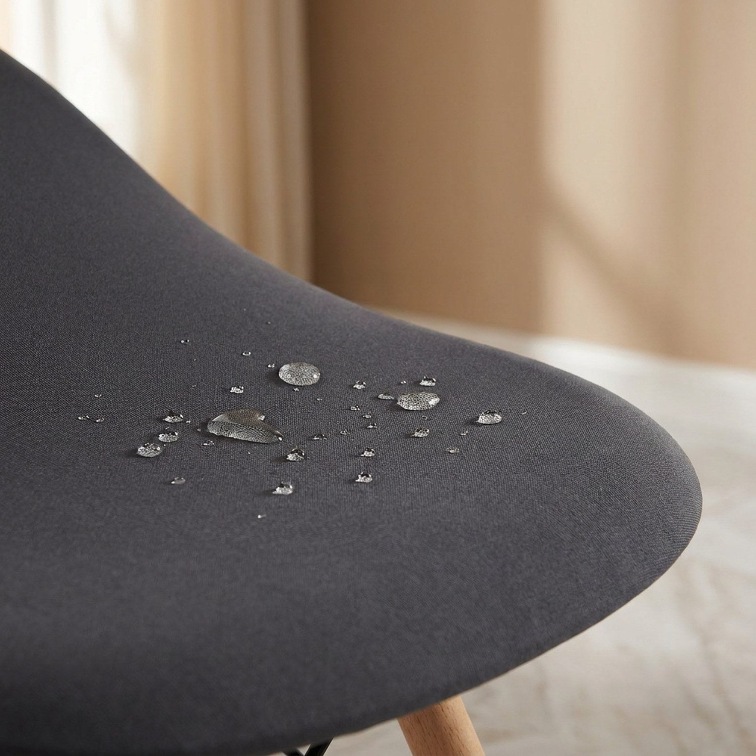 Gros plan de gouttes d'eau perlant sur le tissu impermeable de la housse grise