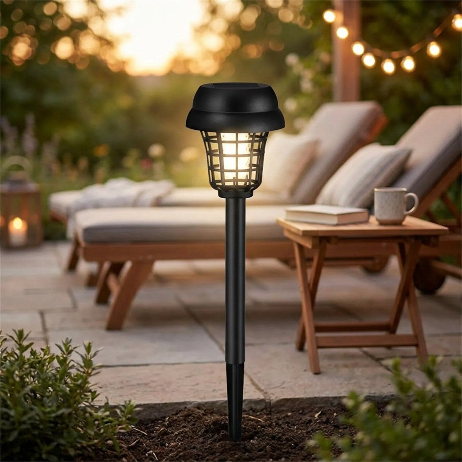 Lampe anti moustique solaire plantée près d'une terrasse cosy au crépuscule