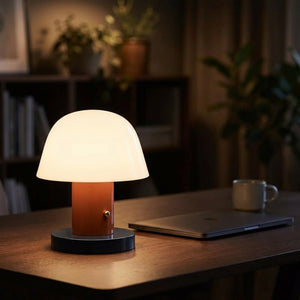 Lampe champignon terracotta allumée sur un bureau le soir