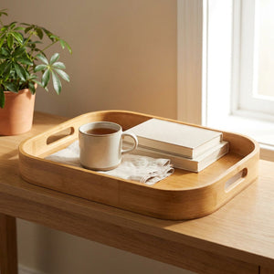 Plateau en bambou avec une tasse de thé et des livres sur une console en bois