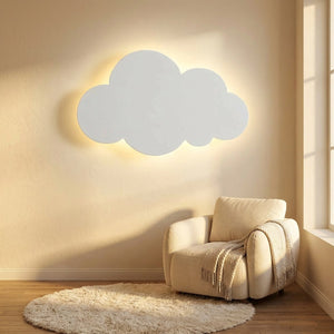 Applique nuage blanche allumée dans un coin lecture avec un fauteuil