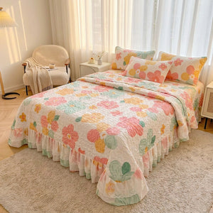 Couvre-lit matelassé fleuri sur un lit dans une chambre lumineuse avec tapis