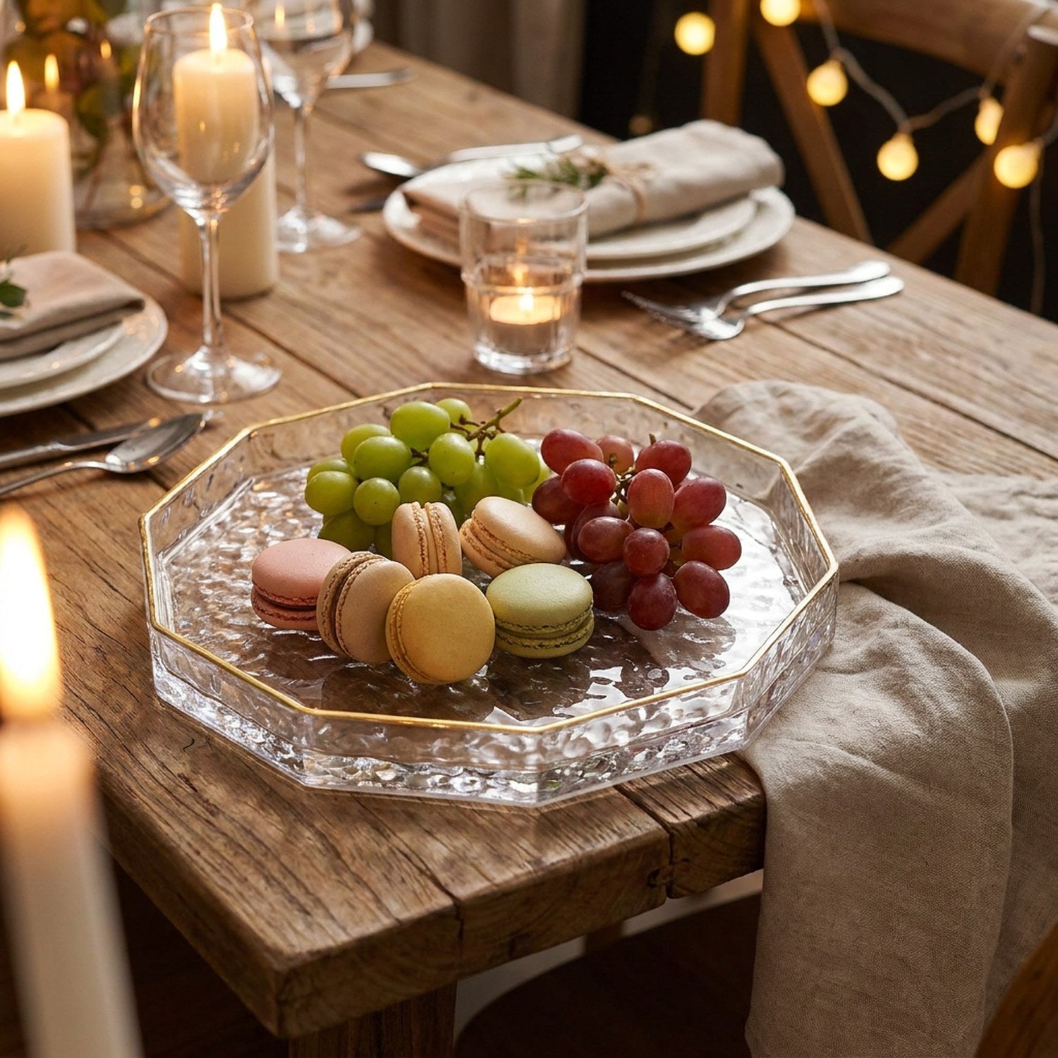 Plateau en verre à facettes présentant des macarons et du raisin sur une table dressée
