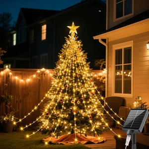Sapin extérieur illuminé par une guirlande solaire devant une maison