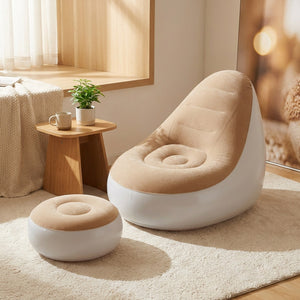 Fauteuil gonflable beige et son pouf dans un coin lecture avec table basse