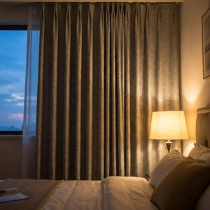 Rideau chenille dans une chambre chaleureuse le soir avec lampe de chevet allumée
