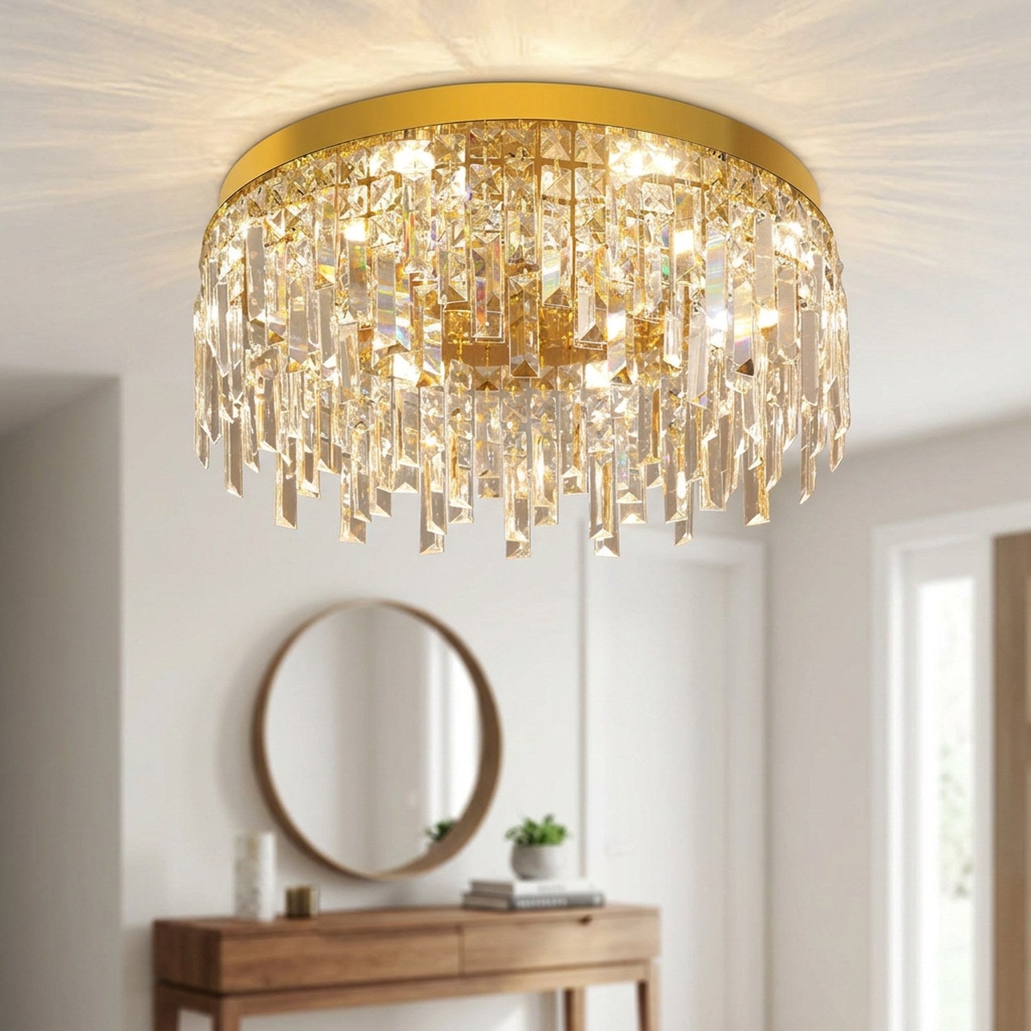 Lustre en cristal doré éclairant une entrée moderne avec miroir rond
