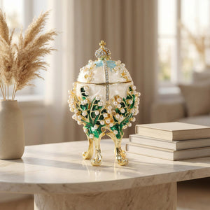 Boîte à bijoux œuf émaillé blanc sur une console en marbre avec pampa séchée