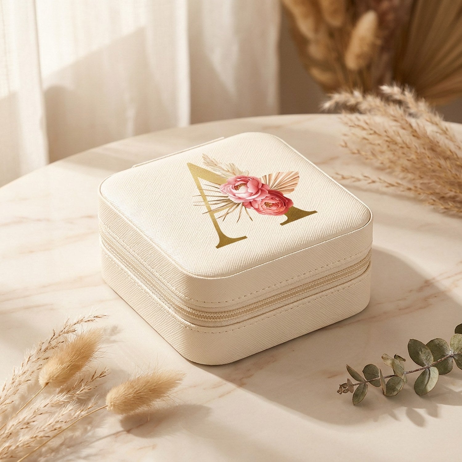 Boîte à bijoux de voyage à initiale dorée sur marbre avec pampa et eucalyptus