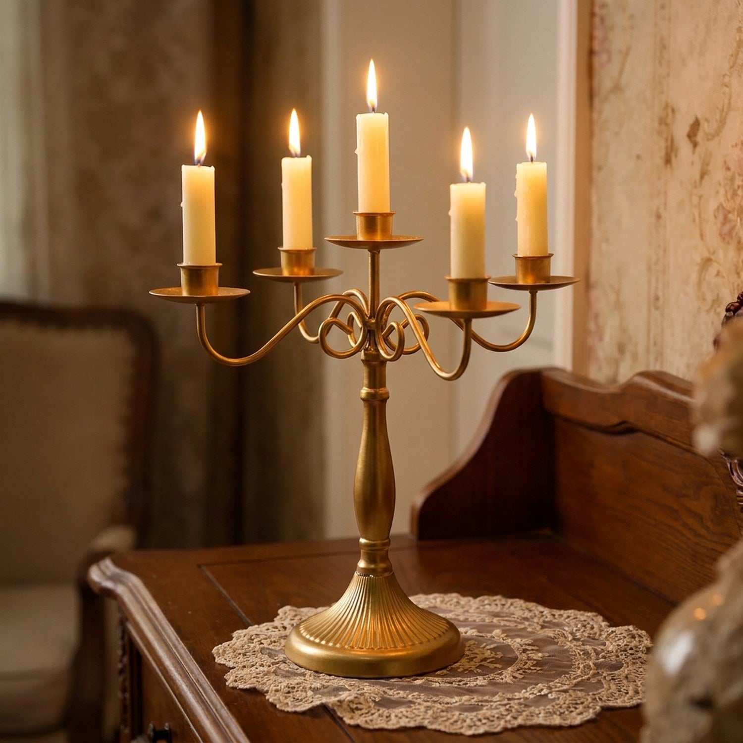 Gros plan sur le chandelier doré et ses bougies allumées sur une console ancienne
