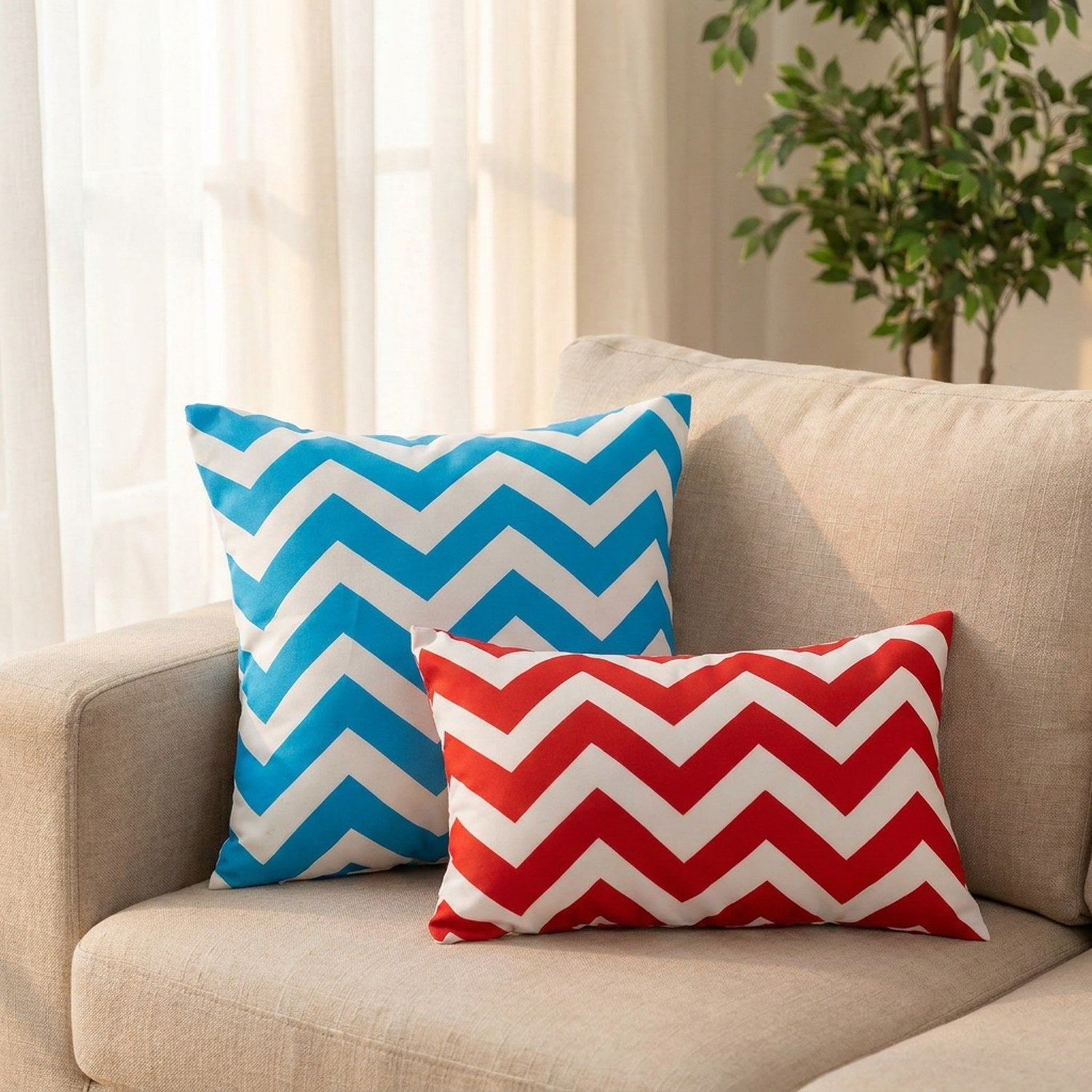 Coussins à chevrons bleus et rouges sur un canapé en lin dans un salon lumineux