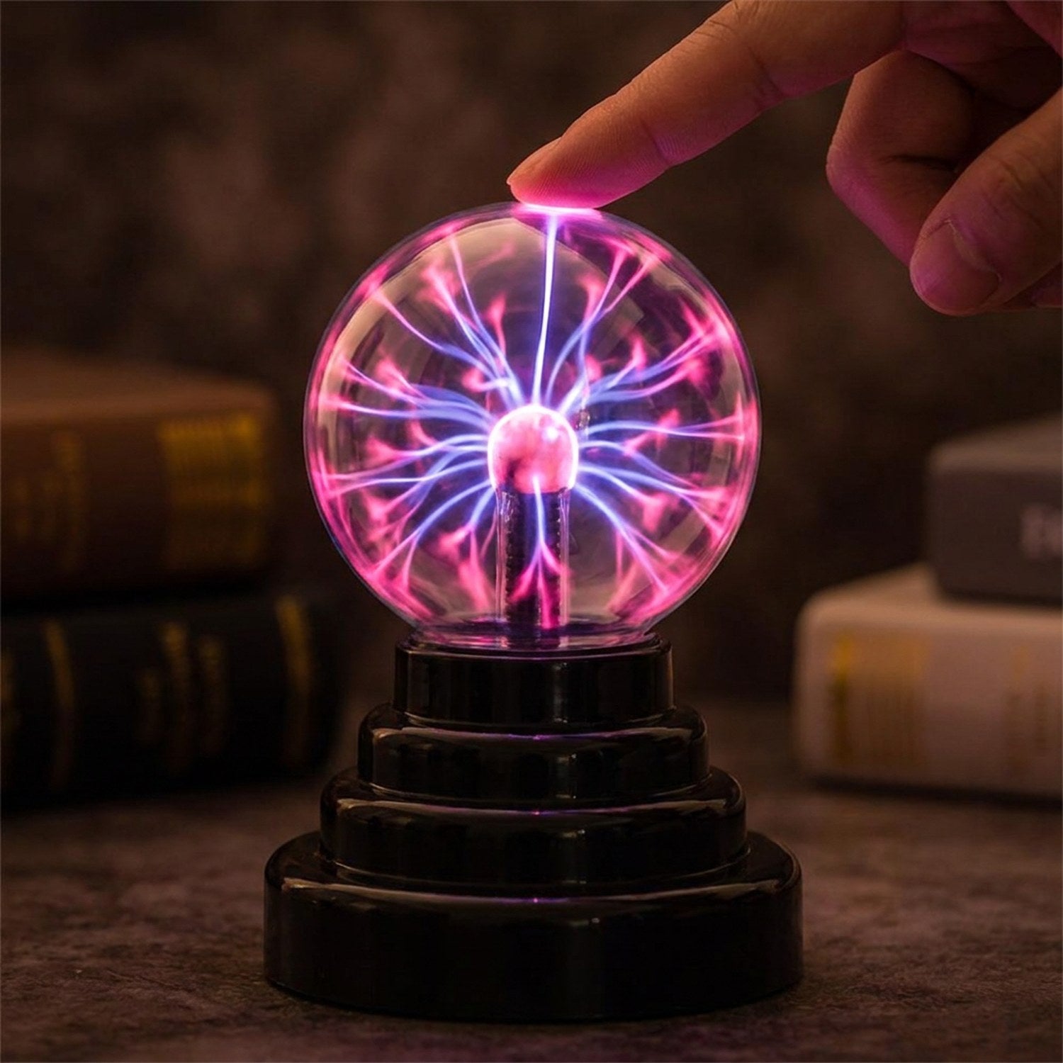 Doigt touchant la boule de plasma dont les filaments suivent le contact