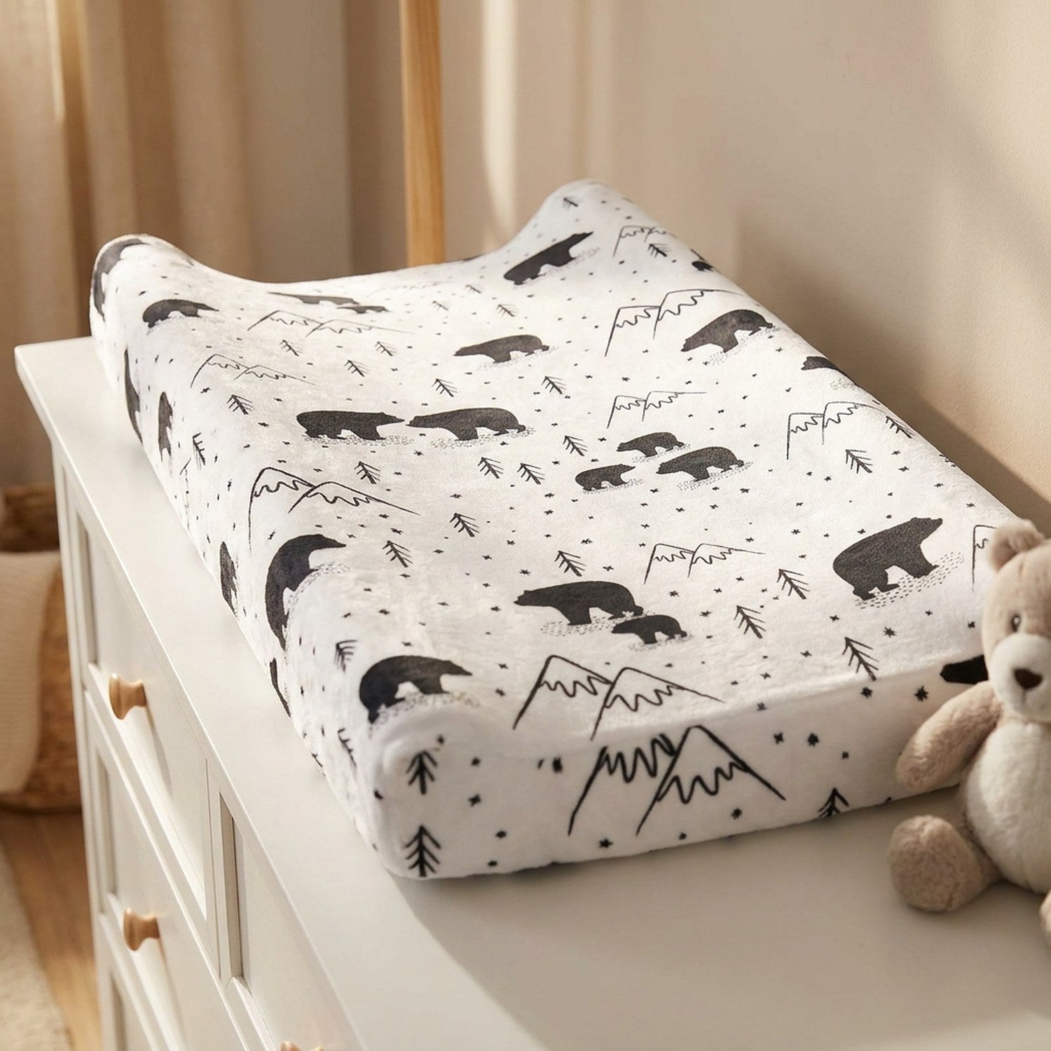 Housse de matelas à langer motif ours avec une peluche dans une chambre lumineuse