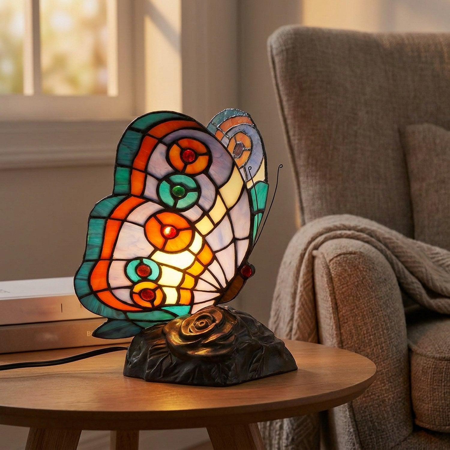 Veilleuse papillon en vitrail allumée sur une table d'appoint près d'un fauteuil cosy