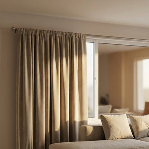 Détail des plis du rideau en velours beige près d'une fenêtre de salon