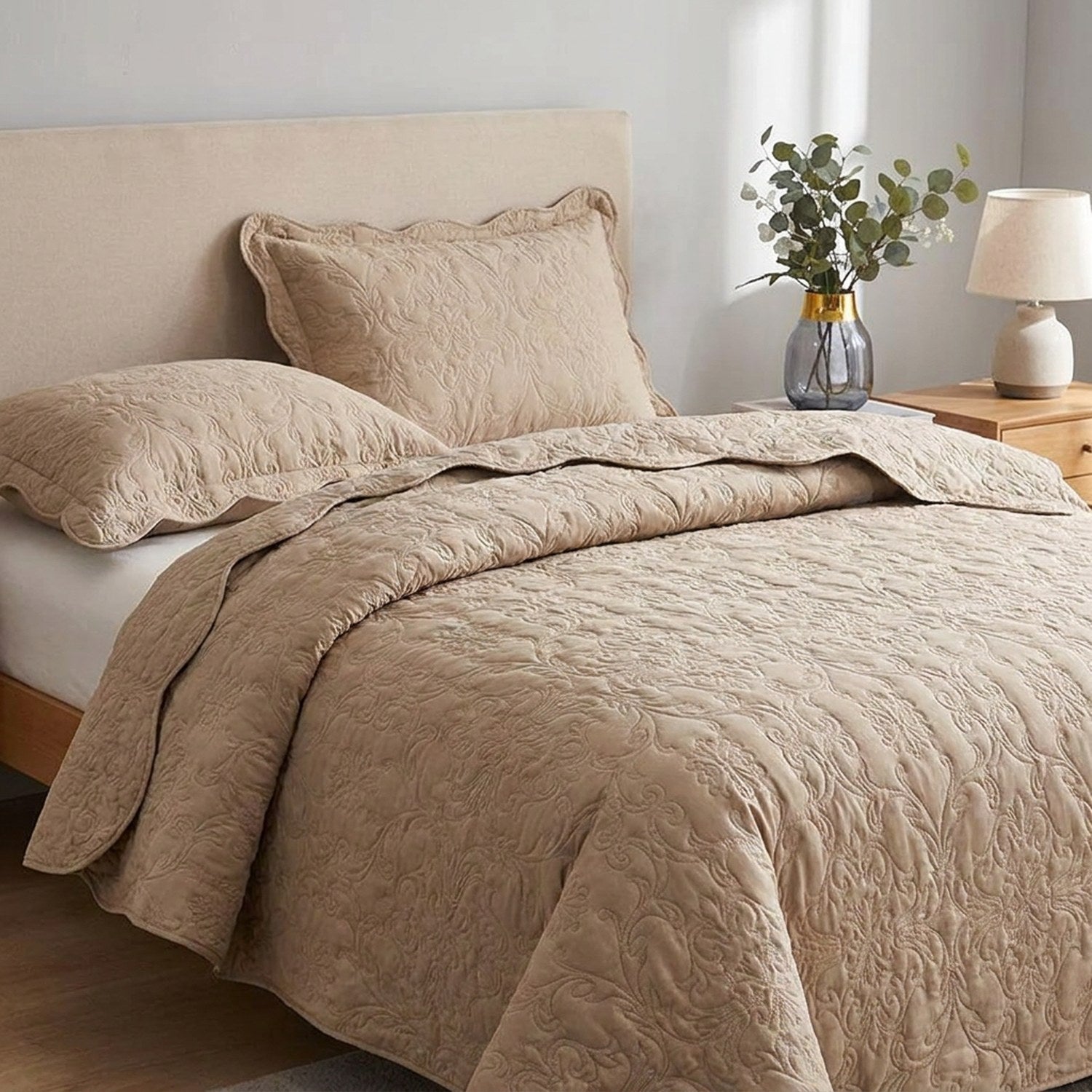 Détail du couvre-lit matelassé beige au motif damassé et de sa taie assortie