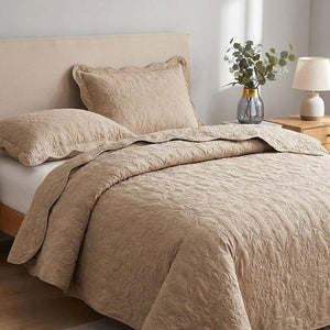 Détail du couvre-lit matelassé beige au motif damassé et de sa taie assortie