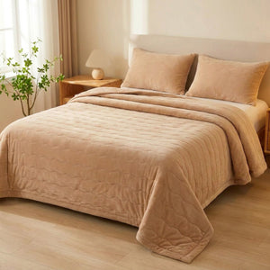 Couvre-lit matelassé beige dans une chambre claire avec une plante verte