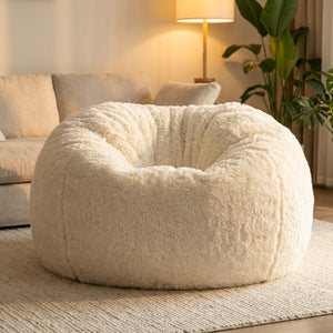 Pouf géant en fausse fourrure blanche dans un salon cosy avec lampe et plante
