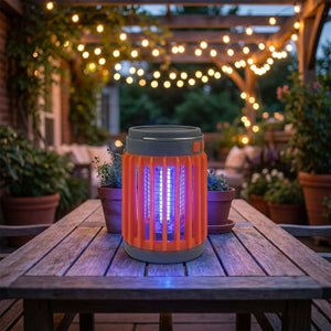 Lampe anti-moustiques UV orange sur table terrasse le soir avec guirlandes lumineuses
