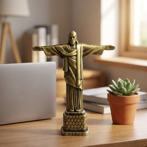 Statue Christ Rédempteur dorée posée sur un bureau en bois avec une plante