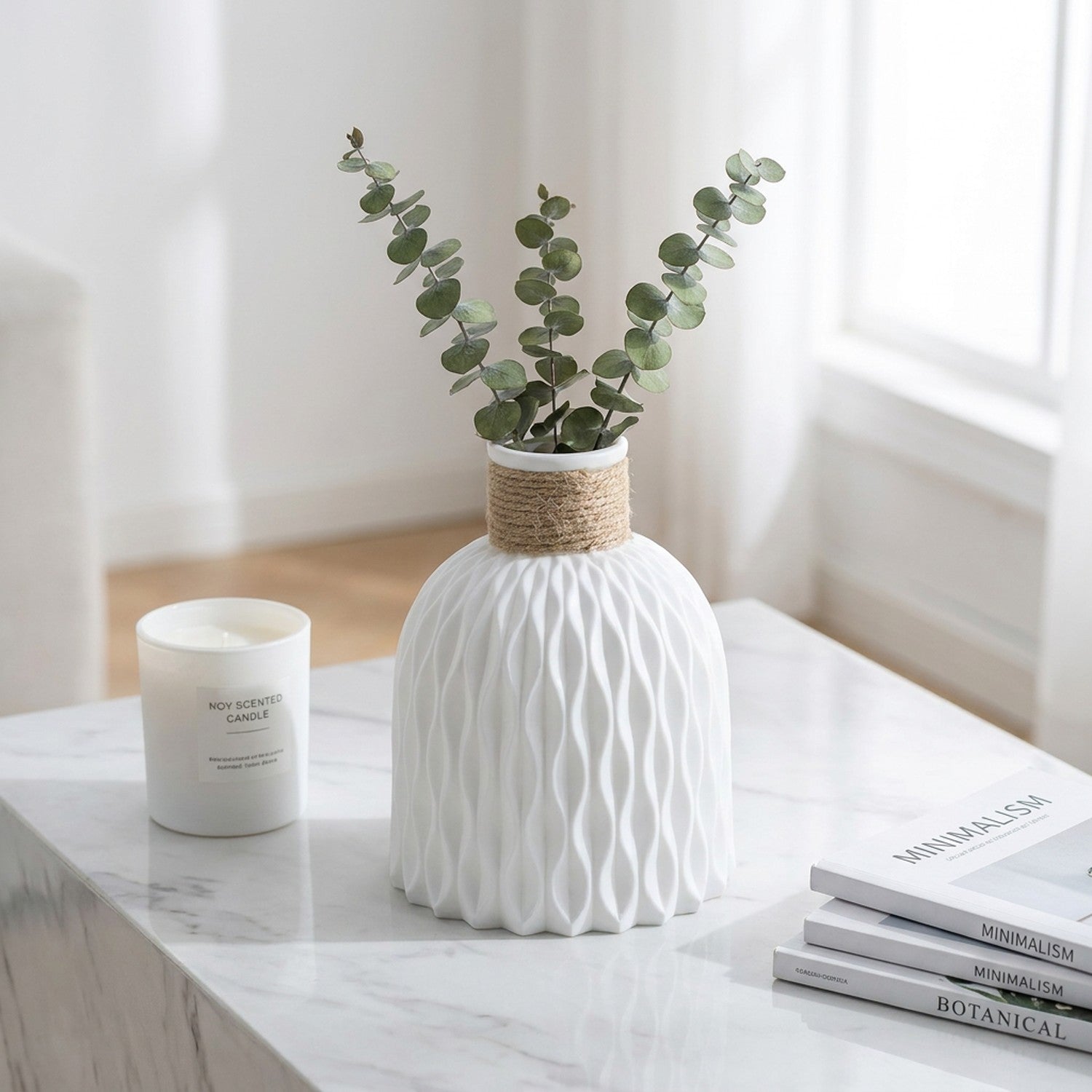 Vase blanc motif ondulé col chanvre sur table en marbre avec bougie et livres
